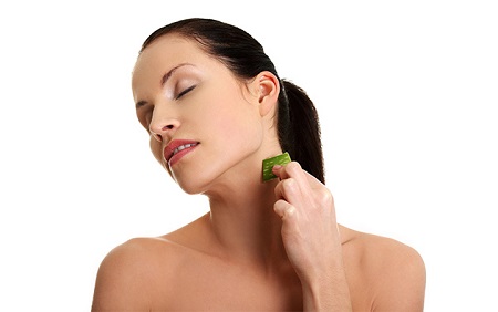 woman applying aloe vera on her face